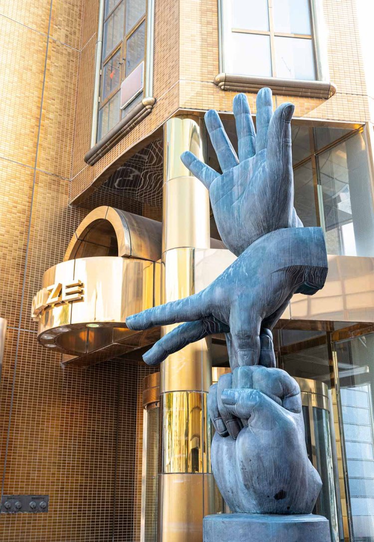 金ぴかビルと並ぶ竹田光幸氏作の彫刻「ぐうちょきぱあ」。