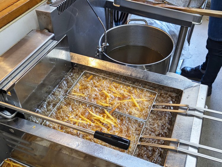 スタッフが時間や温度を計測しながら、フライヤーに付きっきりで揚げる作業している。