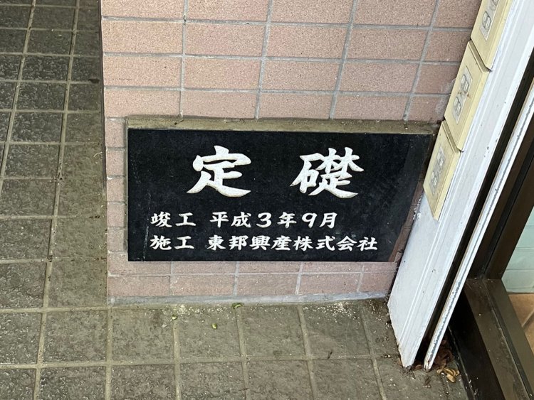 竣工日+施工者タイプ。黒地に白い文字でよく目立つ（府中）。