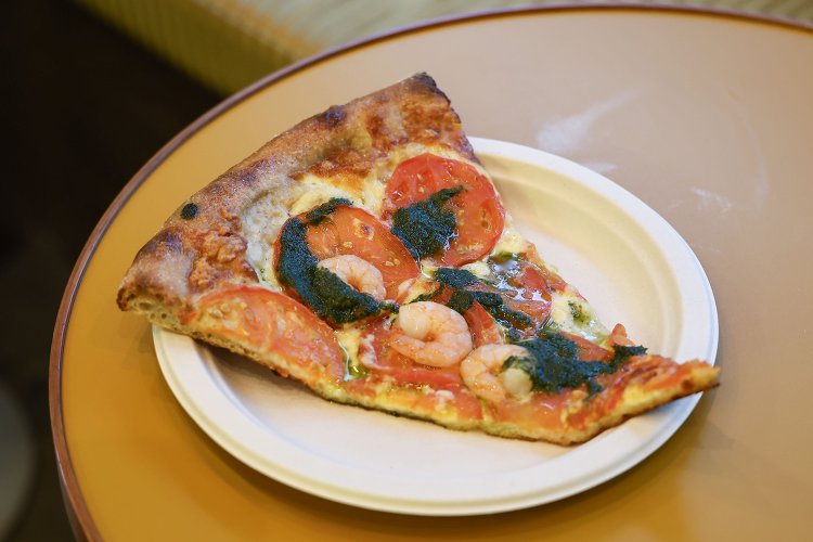 ジェノベーゼとトマト1ピース850円。バジルのフレッシュさが際立つピザ。焼きすぎないから具の食感も生きている。