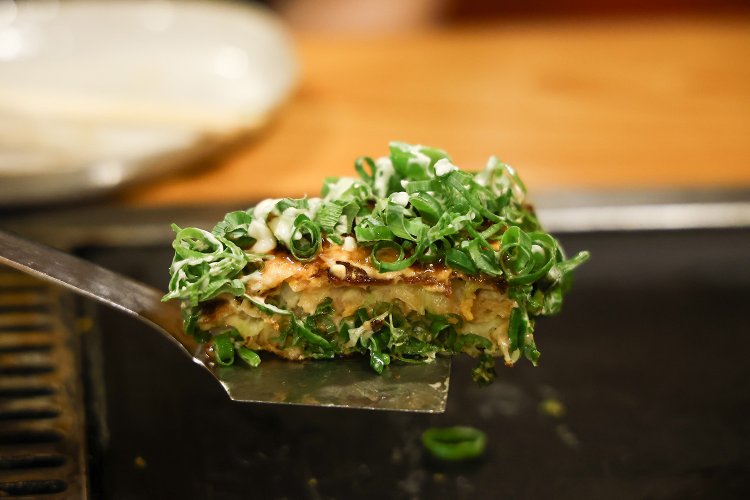 仕上げにたっぷりのネギを振りかける、ひょうたん山スペシャル1200円＋ネギトッピング250円。