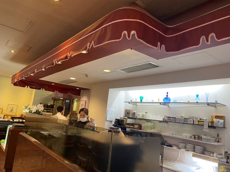 店内のレジ回りエリアを覆うかわいらしい赤いファサード。外気を浴びる公園のテラスにいる気分。