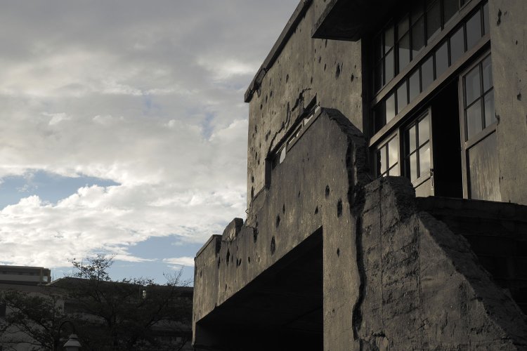 外階段2階の踊り場部分のコンクリート欄干は機銃掃射によって崩れてしまっている。