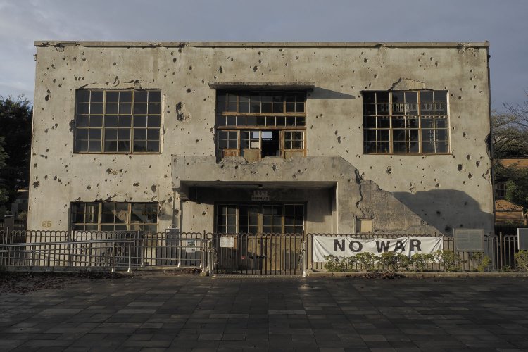 夕日に照らされた変電所。南側壁面は無数の穴が開いていた。これらは全て弾痕と爆裂痕である。