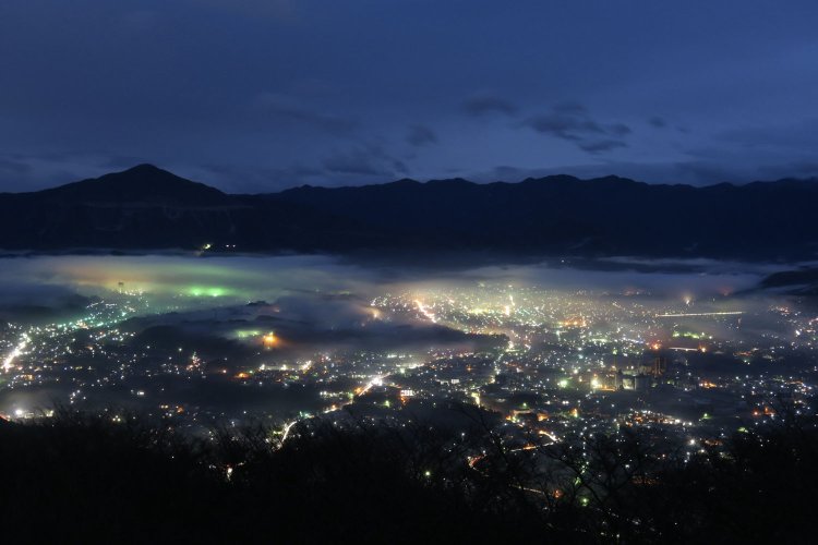 埼玉県秩父市の「雲海夜景」。虹色に光る雲とその下に広がる街並み、地上とは別世界へやってきたようだ（写真提供＝秩父市）。