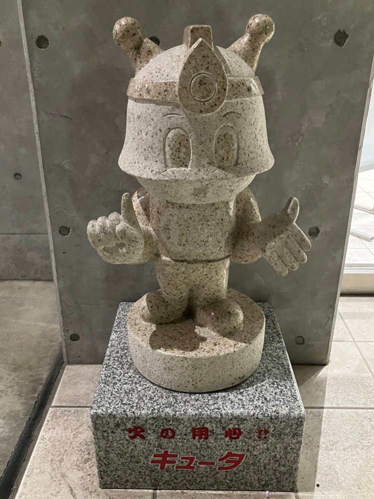 東京消防庁のキャラクター・キュータ。実際は赤スーツに水色ヘルメット、黄色いアンテナとカラフルである（府中消防署）。