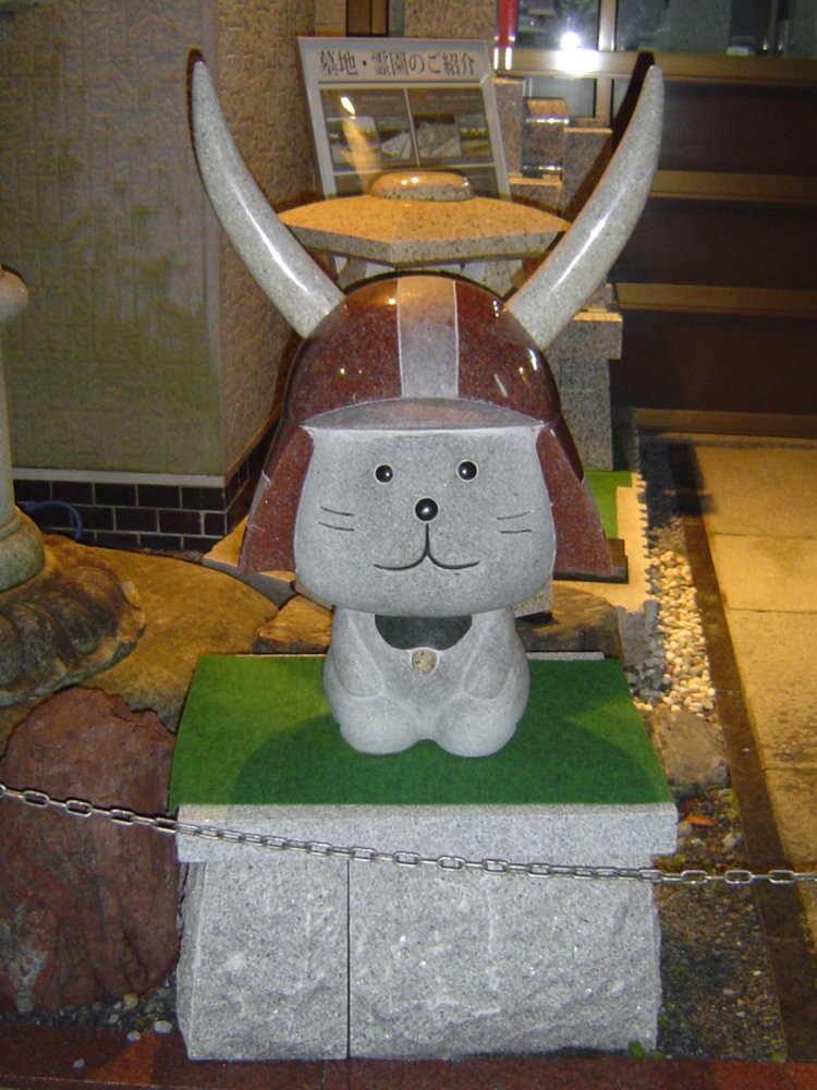 正座をするひこにゃん。よく見ると、赤兜の他にも鈴には黄色い石が使われている。