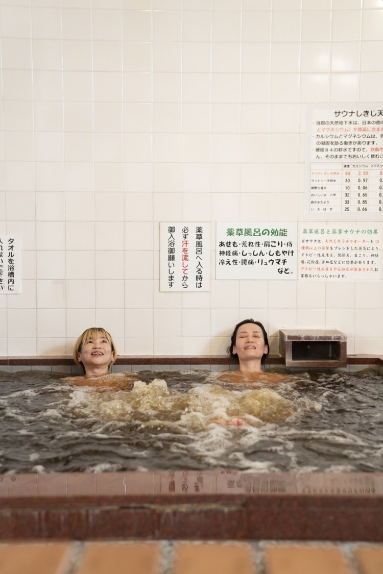 薬草風呂で湯通し。濃厚な香りの湯船は鉱泉の成分と、マツブサやドクダミなど10種以上の薬草を煮出して抽出。お風呂のあとは常備の塩を体にすり込み、シャワーで流したら、再びサウナへ。