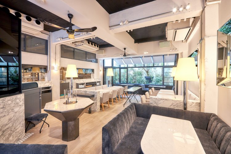 天井が高い1階のメインダイニングは自然光がたっぷり注ぎ込む。大理石のテーブルやベロアのソファなどが置かれ洗練された店内（写真提供＝MERCER BRUNCH EBISU）。