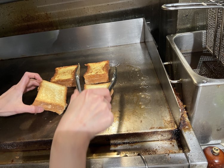 押しつけながらブリオッシュを焼き、均等にこんがりとした焼き色をつけている。