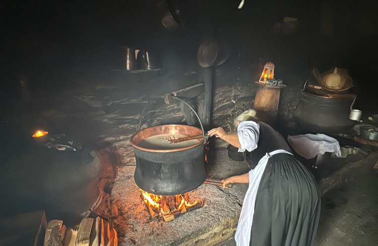 薪をくべて大きな銅鍋で加熱する。
