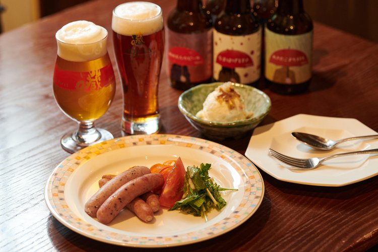 ビールは左から、なまはげIPA660円、古代米アンバー660円。かわい農場のソーセージ（4種）1300円、いぶりがっこのポテトサラダ400円。