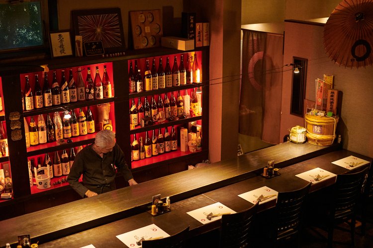 ペンダントライトがともる長いカウンター。和モダンでおしゃれな店内だ。