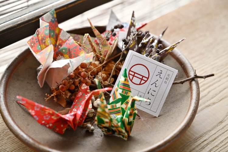 かき氷に敷かれた千代紙で客が折っていくツル。紐通しされ、店を彩る。