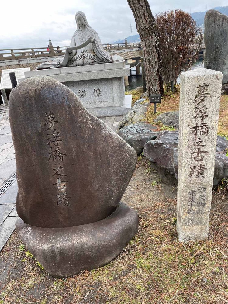 宇治橋西詰「夢の浮橋広場」にある「夢浮橋之古蹟」。その後ろには紫式部像が宇治川を背にして立っている。