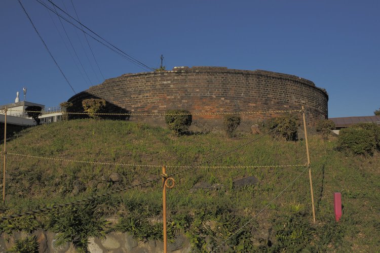 丸山タンクの全景。正円のレンガの壁が残っていて、説明板が無ければ何のためのものか分からない。