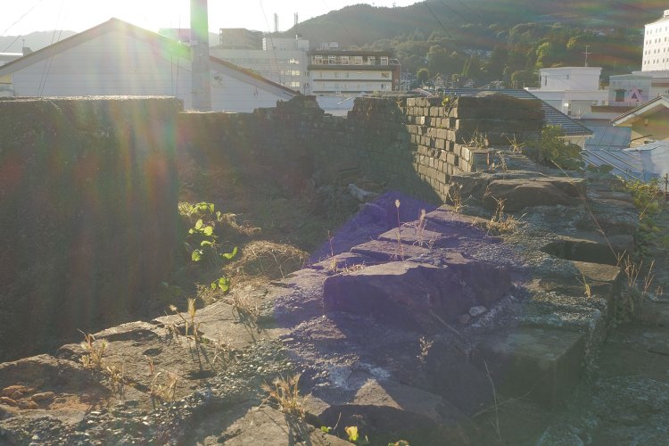 レンガ壁面の上部。この上に水タンクがあった。中心部は正円のコンクリート構造物が2つ残る。逆光でレンガが淡く輝いていた。