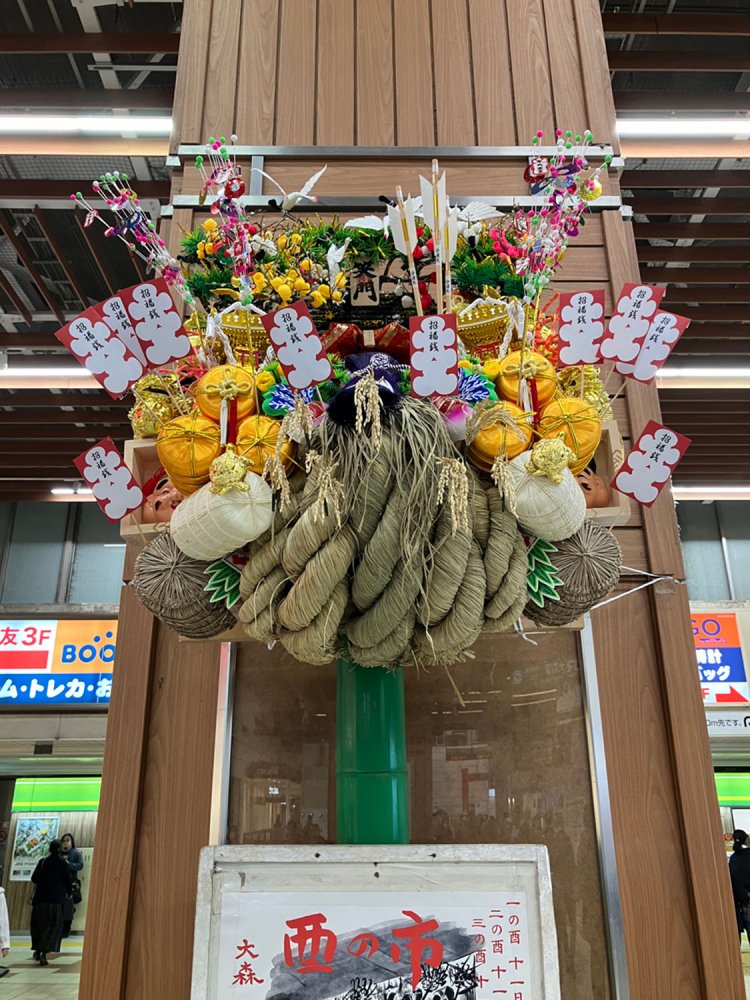 JR大森駅の中央改札前に飾られた大熊手は大森鷲神社のもの。破魔矢や大入袋が多く付けられているのが特徴的。