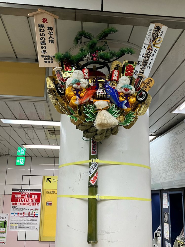 日比谷線入谷駅2番改札に設置された大熊手。だるまはあまり他では見られない。