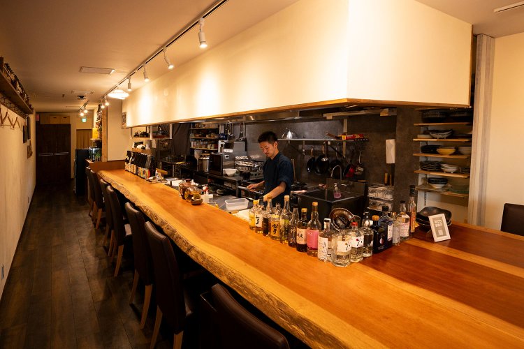 長いカウンターの奥にテーブル席もある。