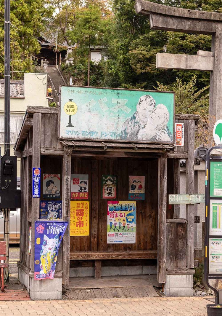 木造のバス待合室をにぎやかに彩るのは猫パロディの看板。