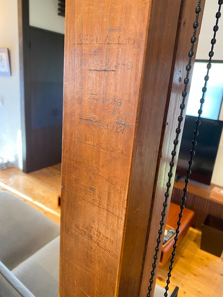 長い時間が育んだ趣ある古民家をリノベーション。柱に刻まれた、この家にかつて住んでいた子供の成長の記録をあえてそのまま残している。