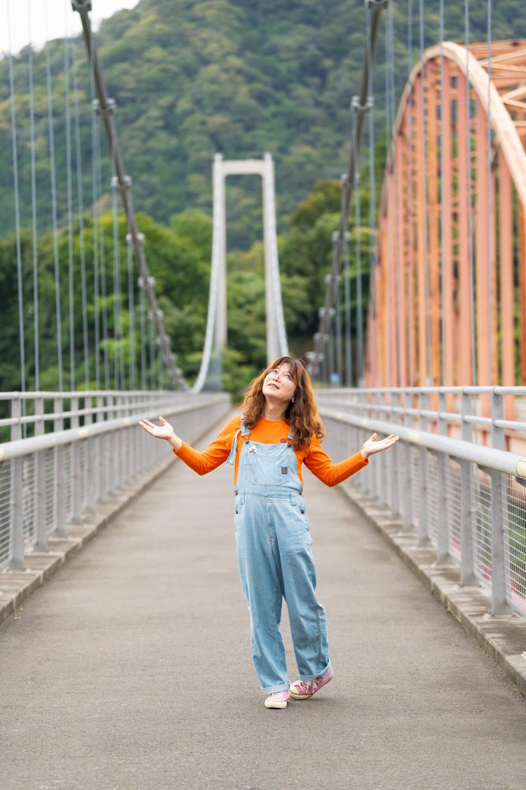 津久井湖に架かる歩行者専用の三井そよかぜ橋。赤いアーチは三井大橋。「津久井湖は大切な水がめなんです」。