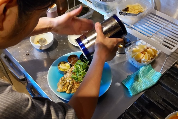 お皿の手前に牡蠣、左側に副菜3種、ご飯の上に生姜、ピーマン、クレソンをのせ、黒胡椒を振りかける。