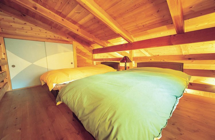 ベッドルームは木の階段を上り2階にある。寝具は京都西川（現・西川）が厳選した上質なものを採用。