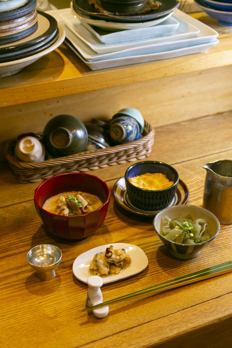 お通し代わりのお酒の友達セット1100円（21時まで）。酒粕入りのもつ煮込みや卵グラタンなど内容週替わりの4品。