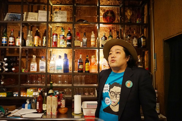 この日もイチオシアーティストというYujiro OzakiのTシャツ姿で話をしてくれたヨシザワさん。出演者への愛情がとても深い。