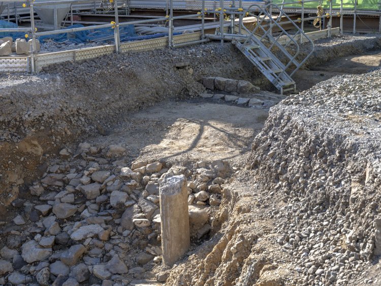 築堤の頂部分には架線柱が突き刺さっていた。奥の石の列が気になるが……。