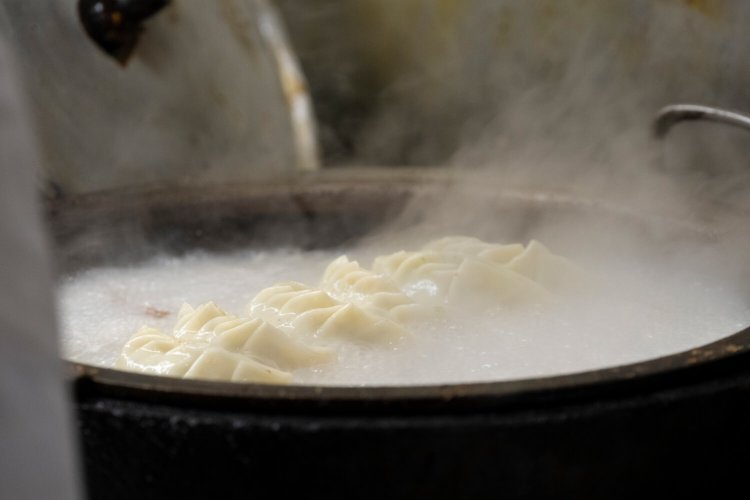 大きな鉄鍋で焼かれるパンチの効いたギョーザ（6個600円、4個400円）も名物。「毎日300個は手包みしていますね」と、匡志さん。