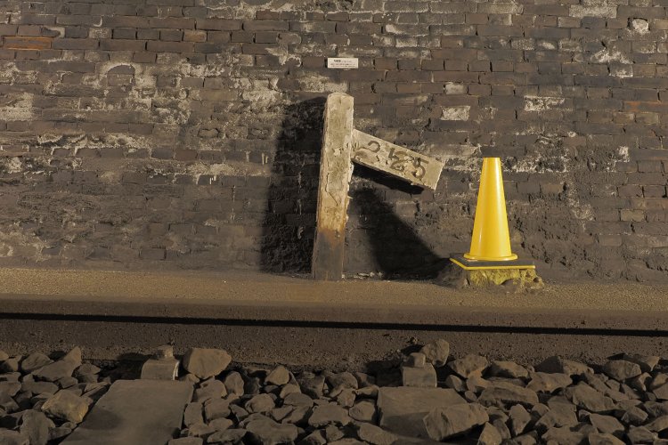 25パーミル勾配を示す勾配表。トンネル内の狭い場所の勾配表の腕木は本来両方にあるが、片方が取れた模様である。