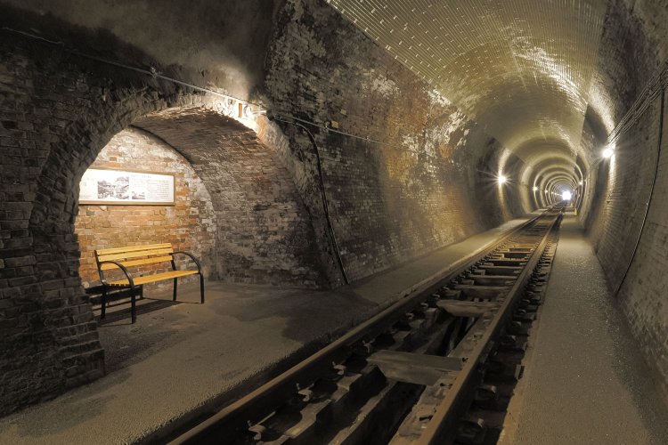 開渠（かいきょ）水路が備わりコンクリート道床となった部分。先ほどとはトンネル内の雰囲気が変わって地下鉄のようにも見える。もう一カ所の大待避所はこの地点にある。