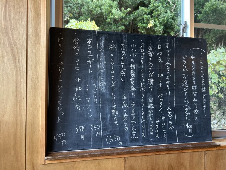 当日のメニューは手書きの黒板に。メインも盛りだくさんの副菜も仕入れや収穫次第で変わる。