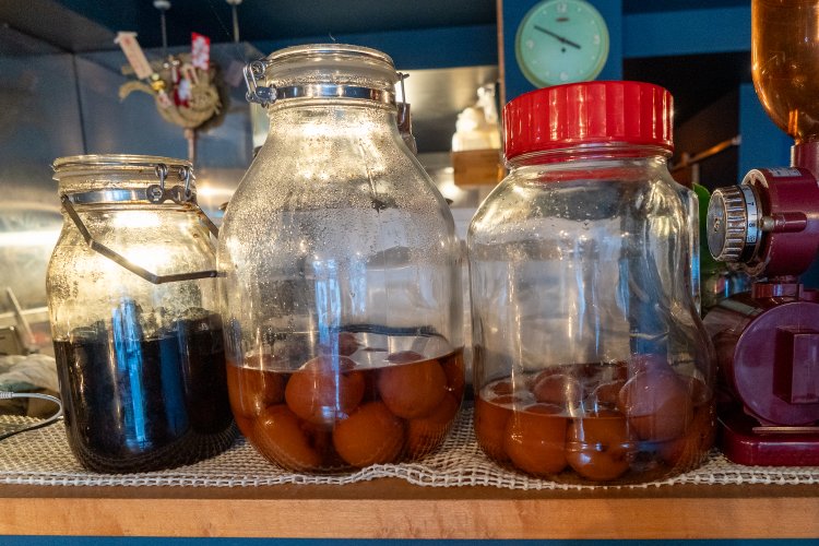 カウンターに置かれた果実酒は550円から。右からプラム、あんず、譲り受けた20年ものの貴重な梅酒。