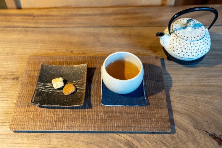 ユリ科の植物の根を使った甘処茶（ドゥングレ茶）ホット580円。セットになった小さなお菓子は甘いものとしょっぱいものが１つずつ。