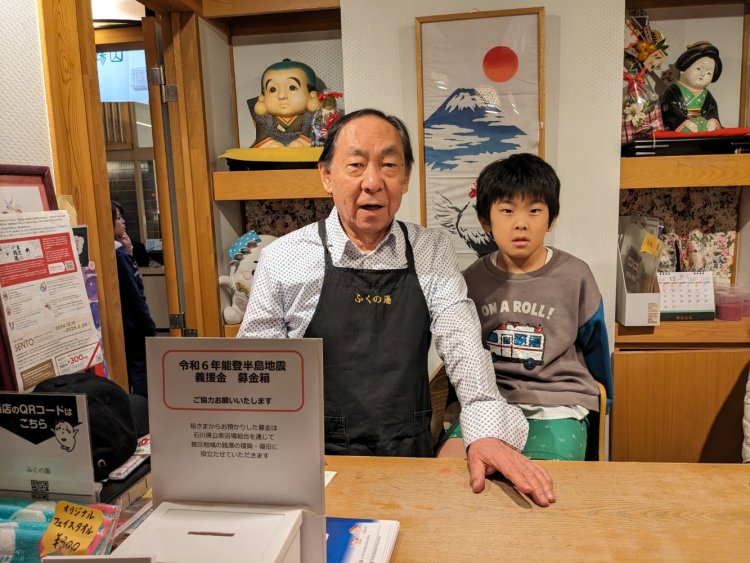 フロントに立つ『ふくの湯』店主の村西彰さんとお孫さん。