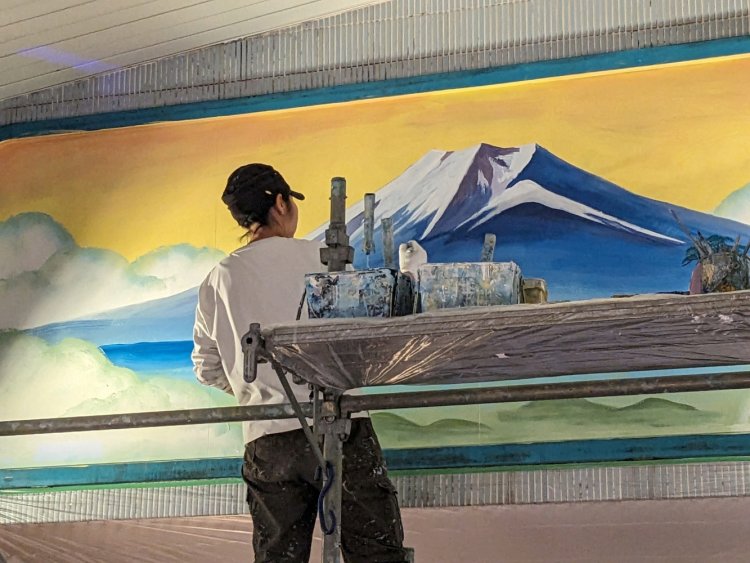 刷毛から細めの筆に持ち替え、細部に色を入れていく田中さん。