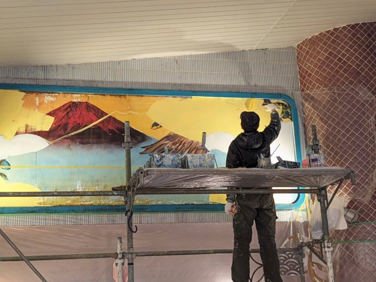 ローラーブラシで背景を塗りつぶしていく田中さん。