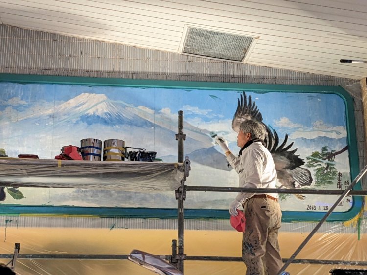 刷毛（はけ）を持ち、真っ先に富士山のアウトラインを引く中島さん。