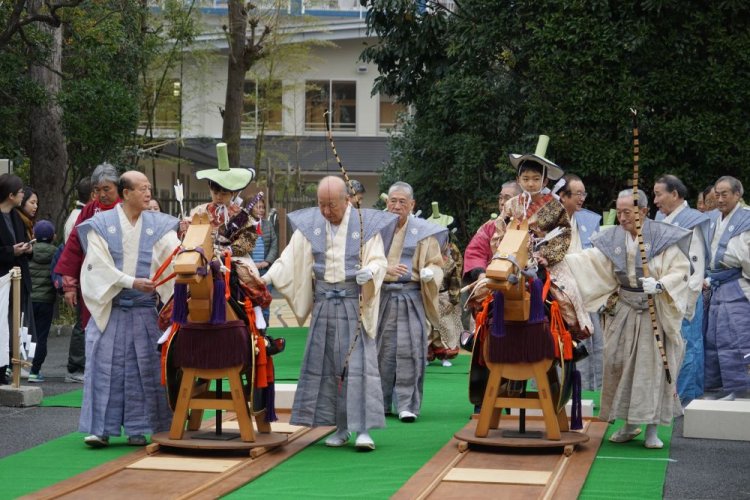 木馬にまたがった子供たちは介添え人に引かれて的の前まで移動する。
