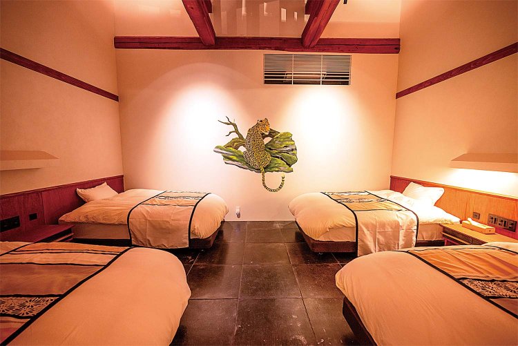 アートで氷見の里山を表現。四つのベッドの先に虎の絵が描かれた客室「MIRE」。