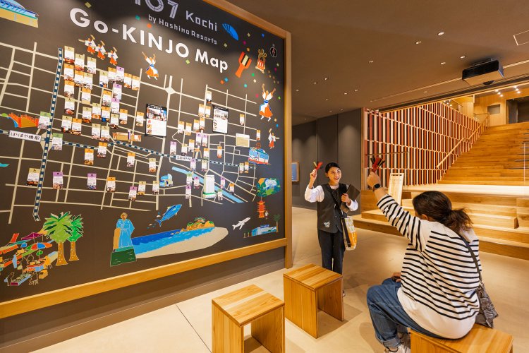 OMOレンジャーたちが作った「ご近所マップ」には、知る人ぞ知る情報が満載。出発前にご近所マップの前で街路市について教えてくれるOMOレンジャー・池内さん。