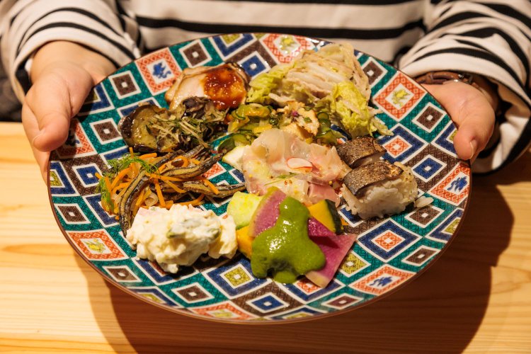 夕食は郷土料理や地元食材を取り入れたビュッフェスタイル。高知の伝統料理・皿鉢（さわち）を作るような演出で料理を選び、皿に取っていく。