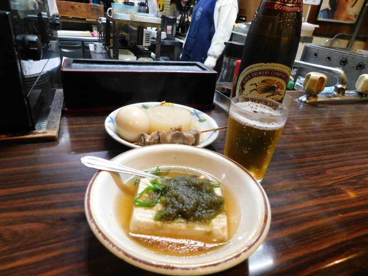 『虎屋』のおでんと大ビン。おぼろ昆布とネギがかかったおでん豆腐は店主のおすすめ。