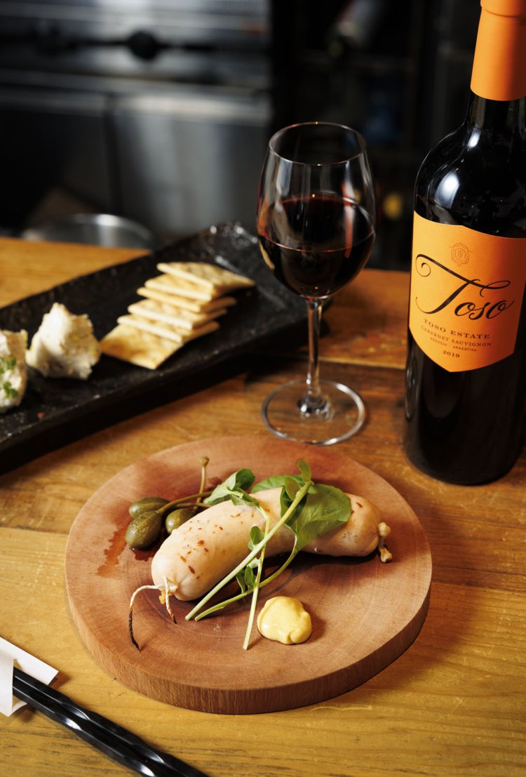 ふわふわ白ソーセージ980円のほか、炭火焼き料理も名物。赤ワインの「トソ・エステイト」はグラス638円。