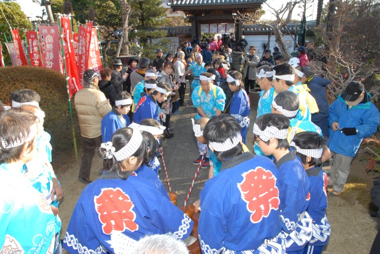 「引き摺り餅」では見物客も一緒に縄を引いて、隣の菅原神社まで臼を引きずる。