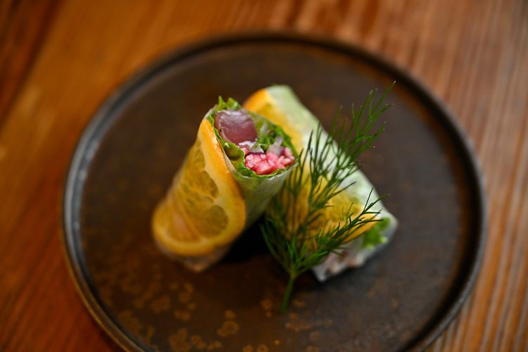 季節の生春巻き（1本）800円。ナンプラーやネパール山椒などのタレに漬けたカツオ、オレンジ、ハーブを巻く。オレンジワインと相性抜群！